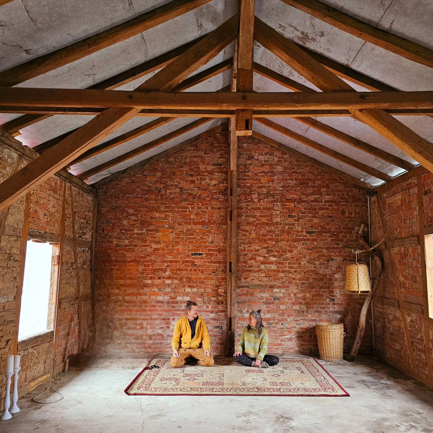 Heller Yoga- und Meditationsraum mit Holzbalkendecke, Backsteinwand und gemustertem Teppich im LIVA Meiningen